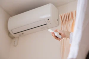 Homeowner adjusting a ductless mini split system during routine mini split maintenance