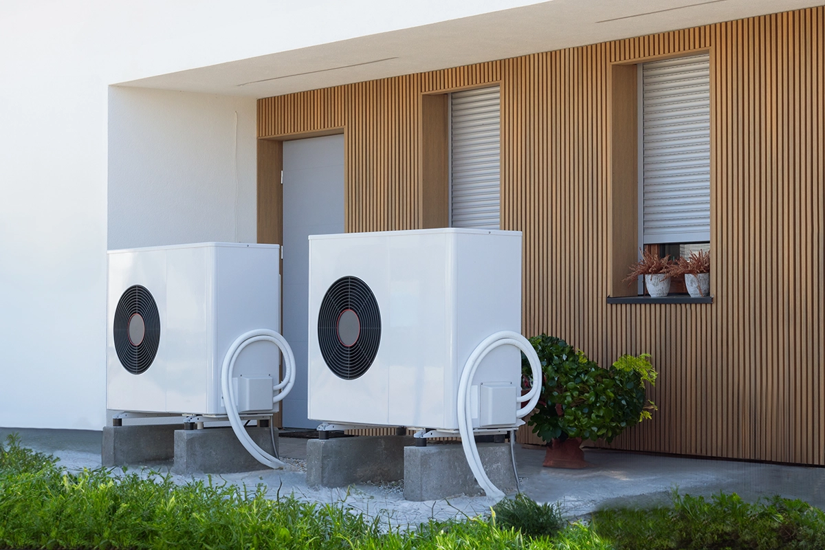 Outdoor heat pump units installed beside a residential home