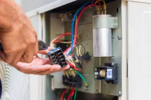 AC contactor replacement inside outdoor air conditioning condenser unit during repair service
